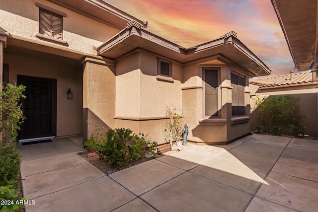 exterior entry at dusk with a patio