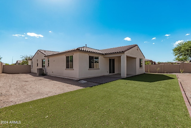 rear view of house with a lawn, cooling unit, and a patio area