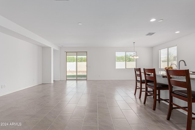 tiled dining room featuring a notable chandelier and a wealth of natural light