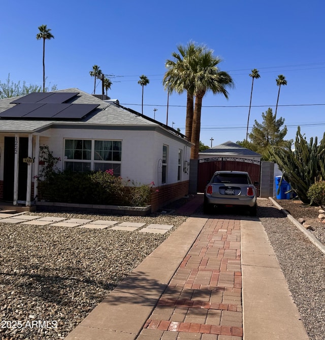 1222 E Almeria Rd, Phoenix, AZ 85006 - view of front of home featuring solar panels, brick siding, fence, and roof with shingles