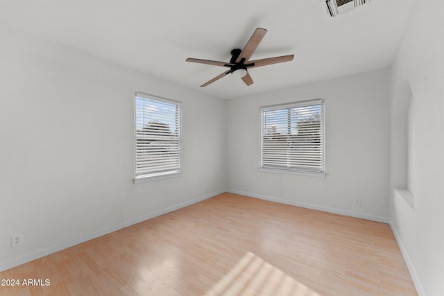 unfurnished room featuring ceiling fan, light wood-type flooring, and a wealth of natural light