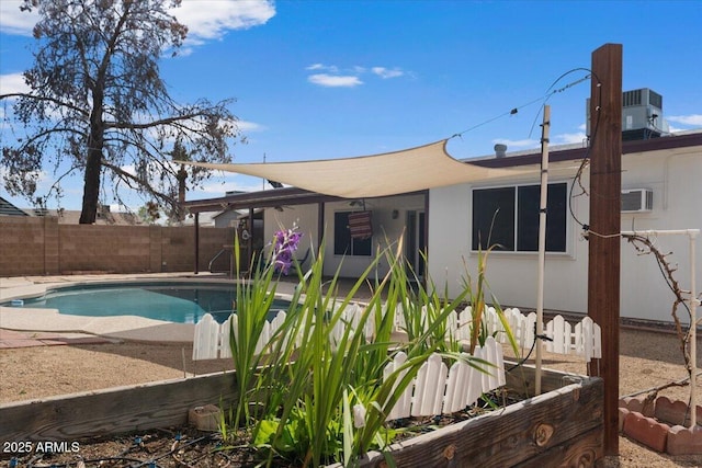 view of pool with a fenced backyard, a wall mounted air conditioner, a fenced in pool, and a patio