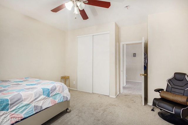 carpeted bedroom with ceiling fan and a closet