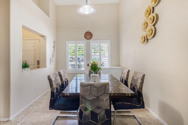 tiled dining area with a high ceiling