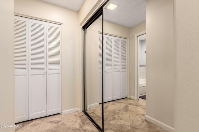 unfurnished bedroom with a textured ceiling and two closets