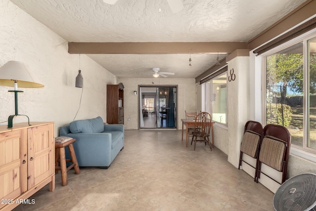 living room featuring ceiling fan and beamed ceiling