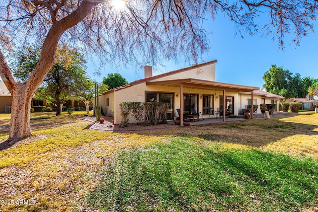 back of house featuring a patio and a yard