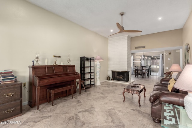 living room with vaulted ceiling, ceiling fan, and a large fireplace