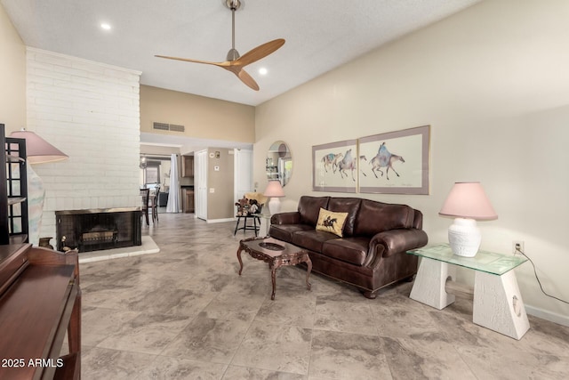 living room with ceiling fan, a brick fireplace, and lofted ceiling