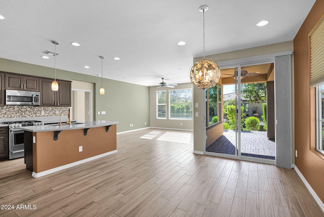 731 E Verde Blvd, Queen Creek, AZ 85140 - kitchen featuring appliances with stainless steel finishes, a ceiling fan, light countertops, open floor plan, and a breakfast bar area