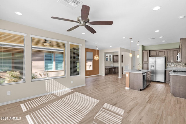 731 E Verde Blvd, Queen Creek, AZ 85140 - kitchen featuring appliances with stainless steel finishes, a center island with sink, light wood-style flooring, light countertops, and open floor plan