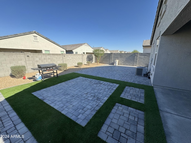 view of yard with cooling unit and a patio