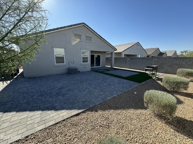 rear view of property featuring a patio and central AC