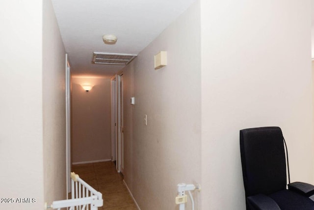 corridor with tile patterned flooring, visible vents, and baseboards