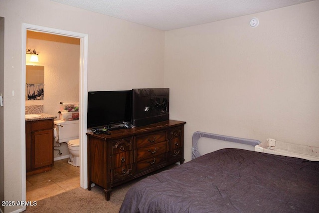 bedroom featuring light carpet and ensuite bath