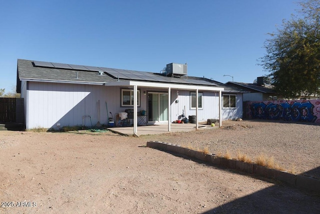 back of house with solar panels and cooling unit