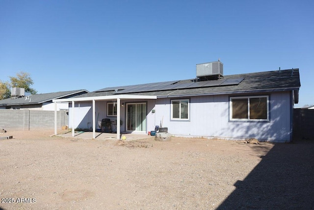 back of house with central AC, solar panels, and fence