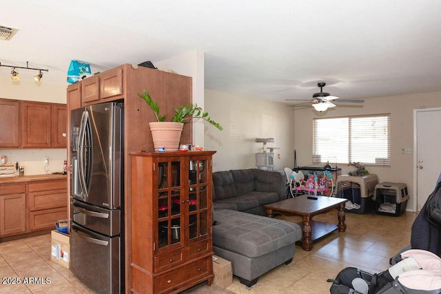 kitchen with open floor plan, light countertops, light tile patterned floors, and stainless steel fridge