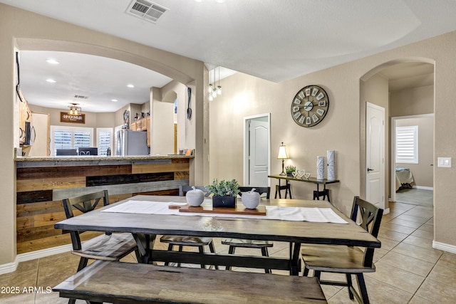 tiled dining room featuring a notable chandelier