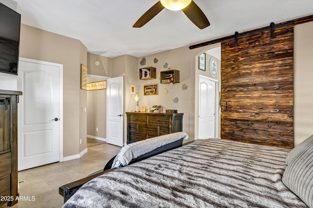 tiled bedroom with a barn door and ceiling fan