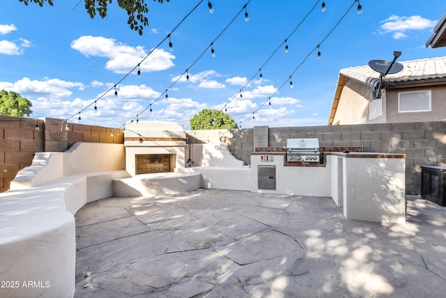 view of patio featuring grilling area, an outdoor kitchen, and an outdoor fireplace