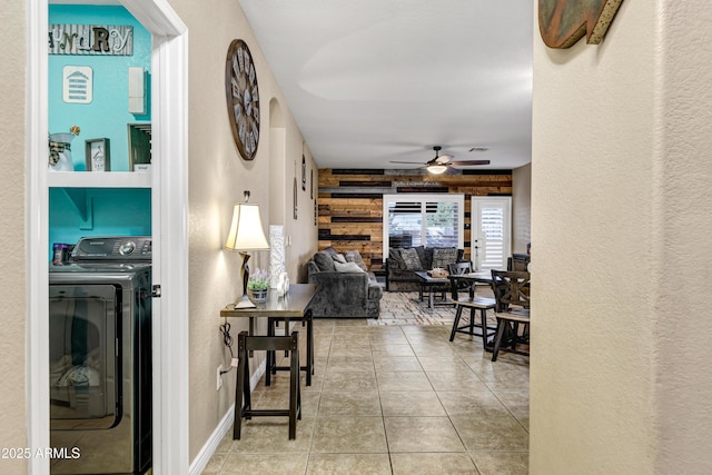 hallway featuring light tile patterned floors and wooden walls