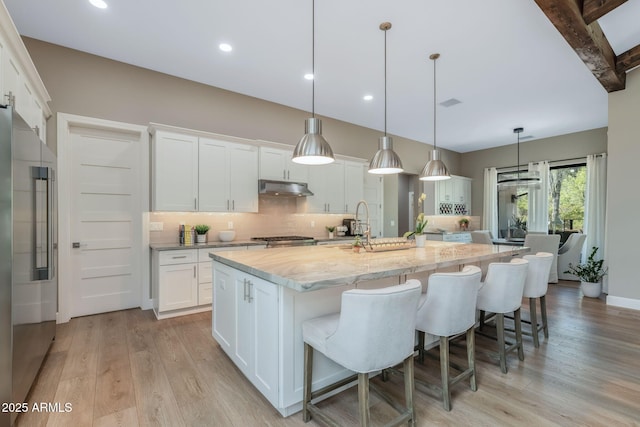 1002 W Rock Springs Cir, Payson, AZ 85541 - kitchen featuring high end fridge, backsplash, a large island, light wood-type flooring, and white cabinetry