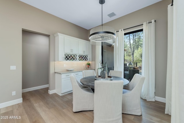 1002 W Rock Springs Cir, Payson, AZ 85541 - dining area featuring baseboards, light wood-style floors, and a dry bar
