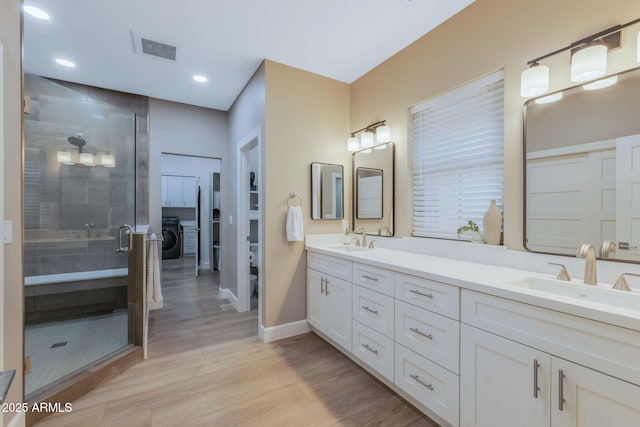 1002 W Rock Springs Cir, Payson, AZ 85541 - full bath featuring double vanity, baseboards, a stall shower, wood finished floors, and washer / clothes dryer