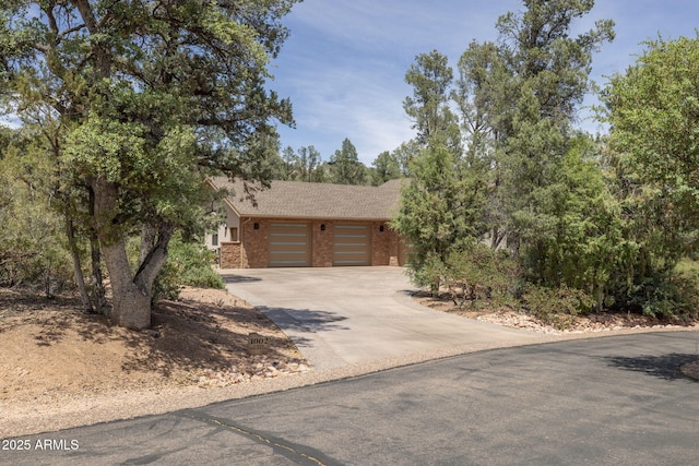 1002 W Rock Springs Cir, Payson, AZ 85541 - view of front facade with concrete driveway, a garage, brick siding, and a shingled roof
