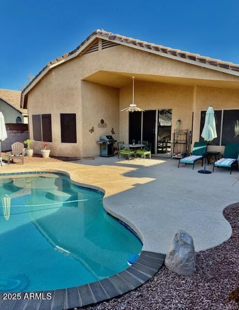 view of swimming pool featuring a grill, a patio area, a fenced in pool, and ceiling fan