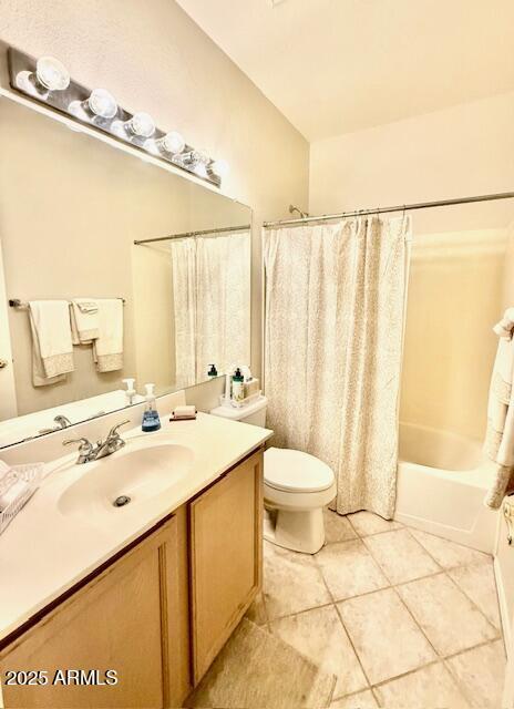 bathroom featuring shower / tub combo, toilet, vanity, and tile patterned flooring