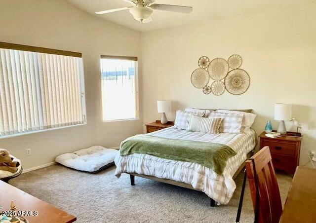 carpeted bedroom featuring lofted ceiling and a ceiling fan