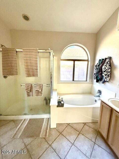 bathroom featuring vanity, a garden tub, a shower stall, and tile patterned flooring