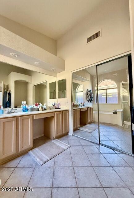 full bath featuring visible vents, two vanities, a sink, tile patterned flooring, and an enclosed shower