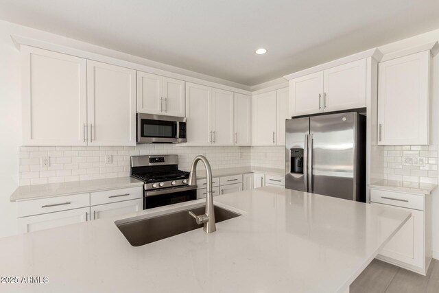 18189 W Hess St, Goodyear, AZ 85338 - kitchen with stainless steel appliances, light countertops, white cabinets, tasteful backsplash, and recessed lighting