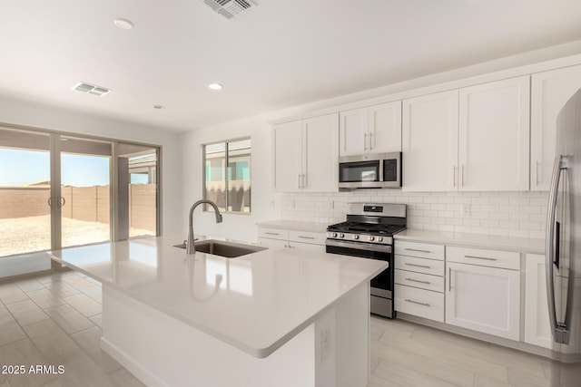 18189 W Hess St, Goodyear, AZ 85338 - kitchen with stainless steel appliances, a sink, decorative backsplash, light countertops, and white cabinets
