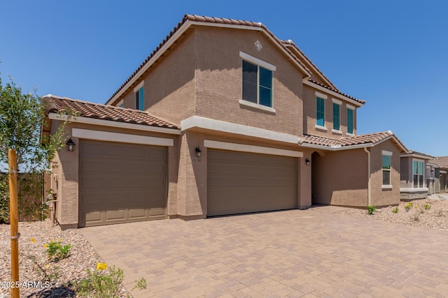 18189 W Hess St, Goodyear, AZ 85338 - view of front of house with a tiled roof, stucco siding, decorative driveway, and an attached garage