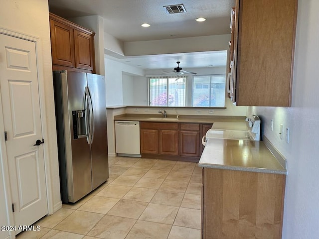 kitchen with sink, white dishwasher, stainless steel refrigerator with ice dispenser, ceiling fan, and stove