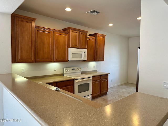 kitchen with sink, white appliances, and light tile patterned flooring