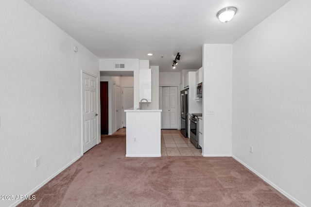 9820 N Central Ave Unit 303, Phoenix, AZ 85020 - kitchen featuring appliances with stainless steel finishes, light carpet, white cabinetry, light countertops, and baseboards