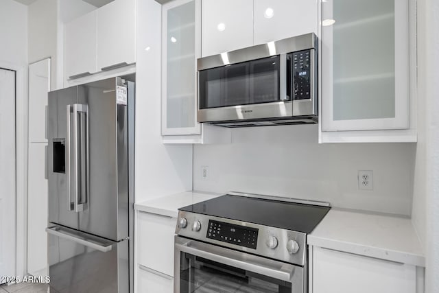 9820 N Central Ave Unit 303, Phoenix, AZ 85020 - kitchen featuring stainless steel appliances, white cabinets, modern cabinets, and light stone counters