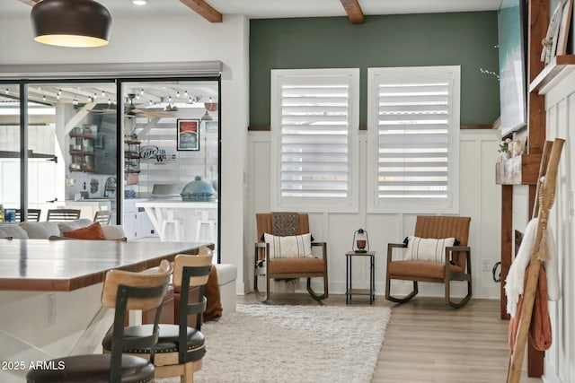 living area with light hardwood / wood-style flooring and beamed ceiling