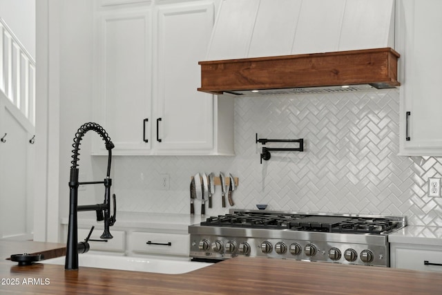 kitchen featuring decorative backsplash, white cabinetry, range, and custom exhaust hood