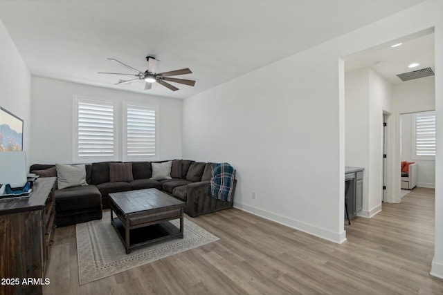 living room with ceiling fan, light hardwood / wood-style flooring, and a healthy amount of sunlight