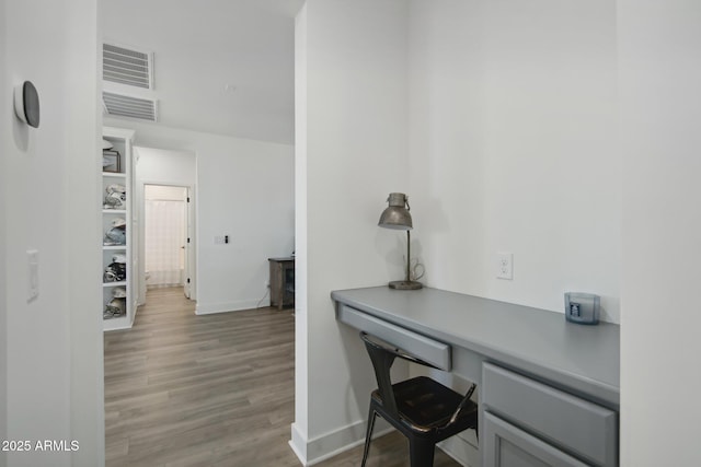 office space featuring light hardwood / wood-style flooring and built in desk