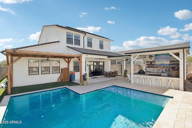 rear view of house with a patio area, an outdoor bar, and ceiling fan