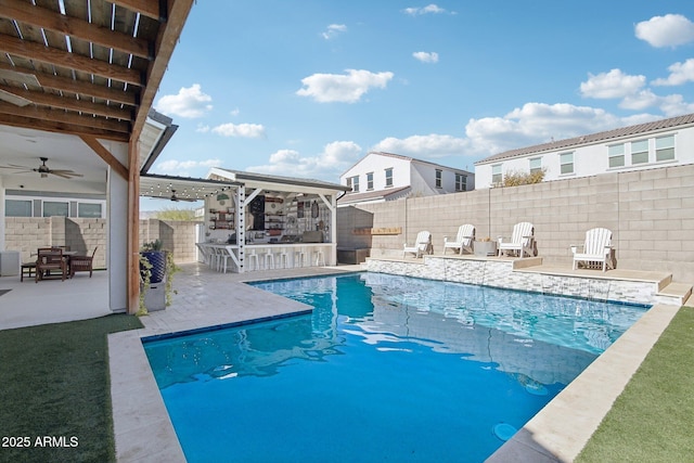 view of swimming pool featuring ceiling fan, exterior bar, and a patio