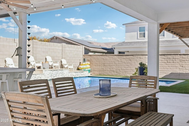 view of patio / terrace featuring a fenced in pool and exterior bar