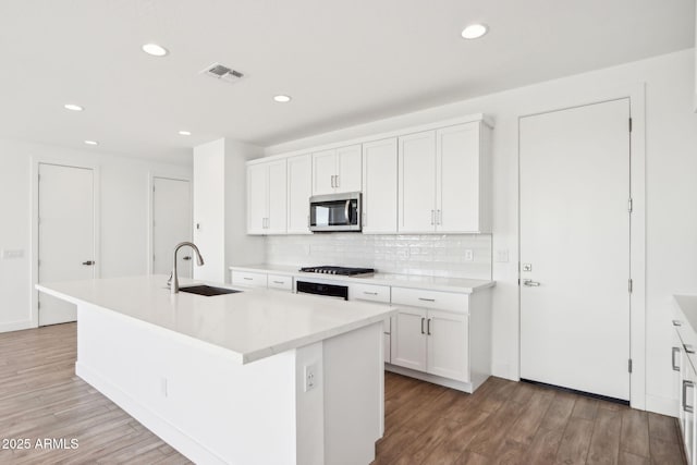 10241 E Ursula Ave, Mesa, AZ 85212 - kitchen featuring stainless steel microwave, a sink, light wood-style floors, tasteful backsplash, and recessed lighting